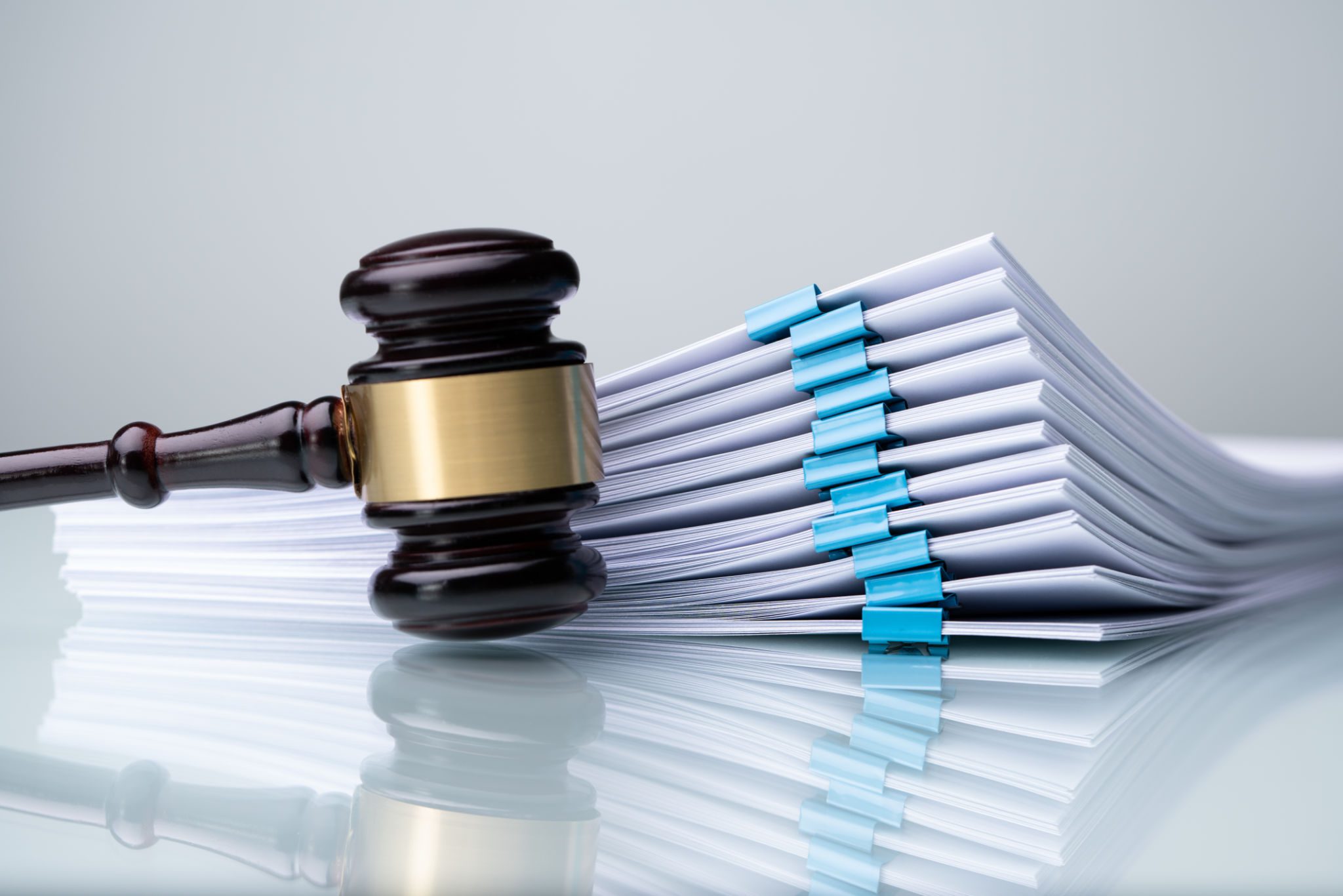 Gavel resting on stacked legal documents.